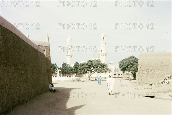 Kano Central Mosque. View down an urban road, looking towards the twin minarets of Kano Central Mosque in the distance. Kano, Nigeria, October 1963. Kano, Kano, Nigeria, Western Africa, Africa.