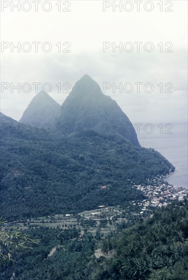 The Pitons, St Lucia. View of the Pitons, two mountains which form St Lucia's most famous landmark, with the coastal town of Soufriere nestling at their base. Soufriere, St Lucia, circa 1975. Soufriere, St Lucia, St Lucia, Caribbean, North America .