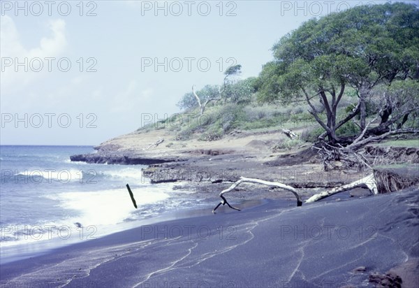 Black sand beach in Grenada. View across a beach of volcanic black sand. Grenada, circa 1975. Grenada, Caribbean, North America .