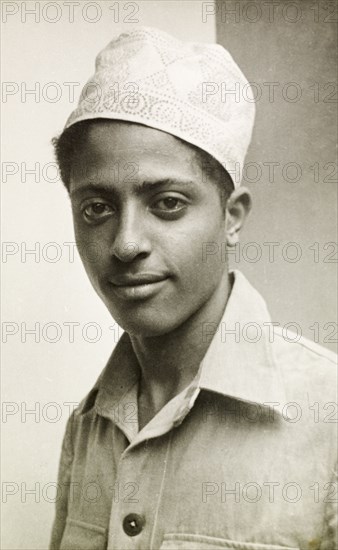 Muslim man wearing a kufi. Portrait of a young Muslim man wearing an embroidered kufi (cap). Lamu, Kenya, circa 1947. Lamu, Coast, Kenya, Eastern Africa, Africa.