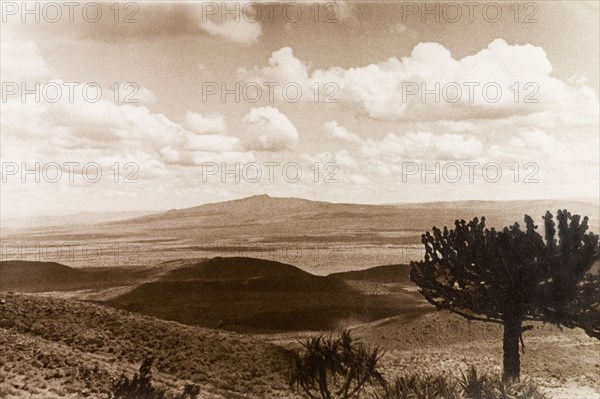 Kenyan landscape. View over the rolling landscape of Kenya, looking towards mountains in the distance. Kenya, circa 1933. Kenya, Eastern Africa, Africa.