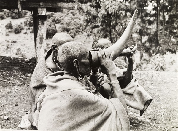 Kikuyu elders drinking beer. Kikuyu elders drink beer from hollow bullock horns, a privilege granted only to tribal elders. Nyeri, Kenya, 1936. Nyeri, Central (Kenya), Kenya, Eastern Africa, Africa.