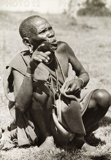 A Kikuyu elder. A Kikuyu elder makes a point during a dispute at a council of elders. Kakamega, Kenya, 1936. Kakamega, West (Kenya), Kenya, Eastern Africa, Africa.