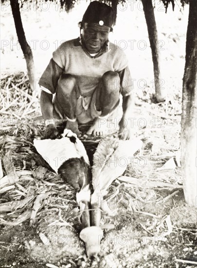 A Kikuyu metalsmith at work. A Kikuyu metalsmith operates a pair of goatskin bellows as he forges tools such as knives, pangas and swords in his workshop. Nyeri, Kenya, 1936. Nyeri, Central (Kenya), Kenya, Eastern Africa, Africa.
