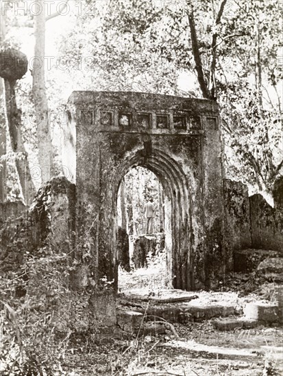 Arch at the ruins of Gedi. An arched stone doorway stands amidst the ruins of Gedi, an ancient Muslim town that was abandoned in the 17th century. The settlement featured a mosque, a palace and several large stone houses, and is thought to have been populated by around 2,500 people. Gedi (Gede), Coastal Region, Kenya, 1933. Gede, Coast, Kenya, Eastern Africa, Africa.