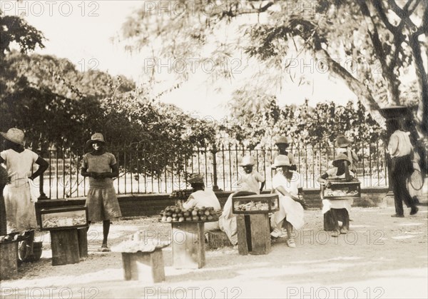 Jamaican street traders. Female street traders sell produce from trays and cases positioned on up-ended fruit boxes. Jamaica, circa 1925. Jamaica, Caribbean, North America .