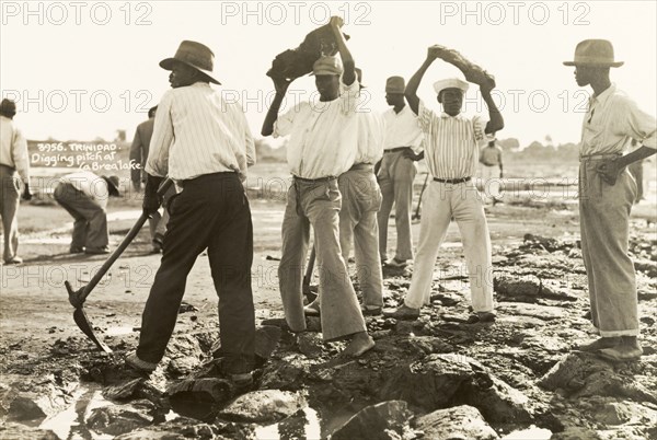 Labourers dig asphalt at the Pitch Lake. Labourers use pickaxes to extract lumps of asphalt from the Pitch Lake, a natural asphalt lake located on Trinidad's west coast. La Brea, Trinidad, circa 1935. La Brea, Trinidad and Tobago, Trinidad and Tobago, Caribbean, North America .