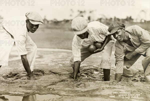 Planting bombs at the Pitch Lake. Three labourers plant bombs into a soft patch of asphalt at the Pitch Lake, a natural asphalt lake located on Trinidad's west coast. They were preparing to conduct a controlled explosion, designed to loosen the asphalt for extraction. La Brea, Trinidad, circa 1935. La Brea, Trinidad and Tobago, Trinidad and Tobago, Caribbean, North America .