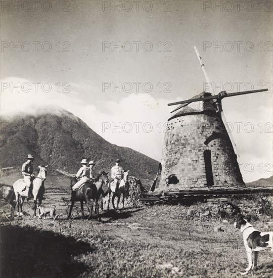 A derelict sugar mill in Nevis. European men on horseback visit a disused windmill on a sugar plantation. Nevis, circa 1939. St Kitts and Nevis, Caribbean, North America .