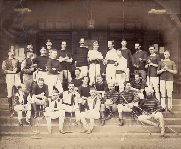 Polo players in Bombay. Uniformed polo teams pose for a group portrait with their polo sticks during a tournament in Bombay. A single turbaned Indian man sits amongst the mainly British crowd. Bombay (Mumbai), India, circa 1883. Mumbai, Maharashtra, India, Southern Asia, Asia.