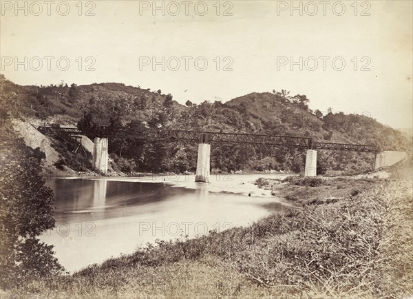 Railway bridge in Ceylon. An iron girder railway bridge runs across a river in Ceylon. Ceylon (Sri Lanka), circa 1865. Sri Lanka, Southern Asia, Asia.