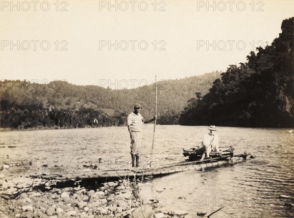 Rafting on the Rio Grande, Jamaica. A European man is ferried across the Rio Grande aboard a raft made from lengths of bound bamboo. Near Port Antonio, Portland, Jamaica, circa 1921., Portland, Jamaica, Caribbean, North America .