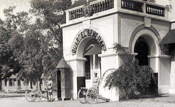 General Barracks at Panjim. Armed guards stand beside mounted artillery guns outside a 'Quartel General' (General Barracks) belonging to the Indian Army. Panjim, Goa, India, 1937. Panjim, Goa, India, Southern Asia, Asia.