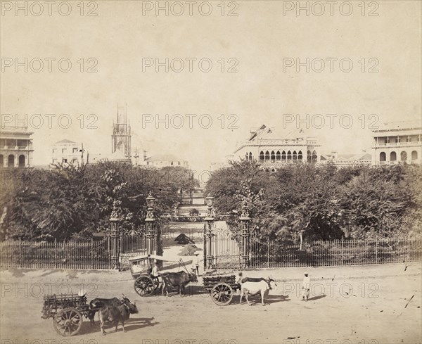 Entrance to the Horniman Circle Gardens. Cattle-drawn carts stand outside ornate iron gates at the entrance to Horniman Circle Gardens. This large park in southern Bombay was also known as Elphinstone Circle, named after Lord Mountstuart Elphinstone (1779-1859), Governor of Bombay between 1819 and 1827. Bombay (Mumbai), India, circa 1883. India, Southern Asia, Asia.