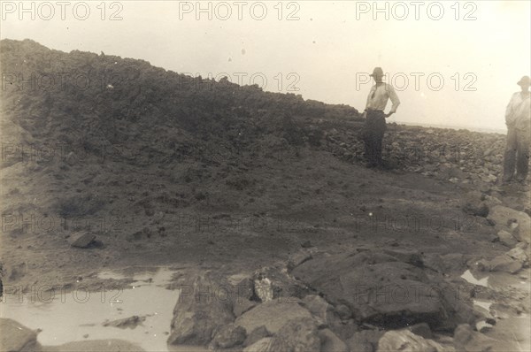 The highest point on the island of Trinidad. Two figures stands on a rocky incline at the highest point on the island of Trinidad. Trinidad, circa 1912. Trinidad and Tobago, Caribbean, North America .