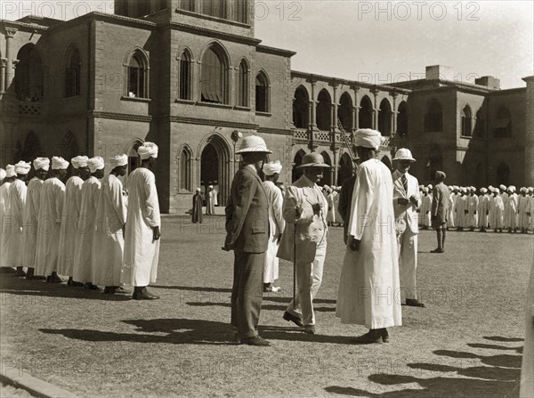Rudolf von Slatin visits Gordon College. Sir Rudolf Carl von Slatin inspects a line of African men wearing white robes and turbans in a courtyard outside Gordon College. Khartoum, Sudan, 1926. Khartoum, Khartoum, Sudan, Eastern Africa, Africa.