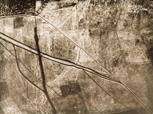 Aerial view of a battlefield under snow. One of a series of British aerial reconnaissance photographs recording the positions of trenches on the Western Front during the First World War. An original caption indicates the position of a British Field Battery Company, marked by a line of black dots in the top left hand corner. A strongly fortified trench zig-zags its way north to south, crossed by the dark lines of transport tracks. Nord-Pas de Calais or Picardie, France, 22 December 1917., Nord-Pas de Calais, France, Western Europe, Europe .