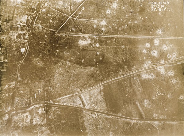 Vue aérienne des restes d'un village français du Nord-Pas-de-Calais ou de Picardie, entouré de champs grêlés de trous occasionnés par des bombes.
Photo faisant partie d'une série de photographies de reconnaissance aérienne britanniques enregistrant les positions des tranchées sur le front occidental pendant la Première Guerre mondiale. 
22 Décembre 1917.
