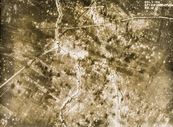 Aerial view of a bomb-damaged landscape. One of a series of British aerial reconnaissance photographs recording the positions of trenches on the Western Front during the First World War. Square-toothed trenches zig-zag across fields pockmarked with bomb craters. Drifted snow covers older shell holes, making them appear white in contrast to more recent, black craters. Nord-Pas de Calais or Picardie, France, 22 December 1917., Nord-Pas de Calais, France, Western Europe, Europe .