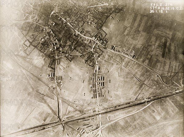 British military camp in a ruined village. One of a series of British aerial reconnaissance photographs recording the positions of trenches on the Western Front during the First World War. A British military camp, based on the outskirts of a bomb-damaged village. An original caption identifies the positions of horse standings (long sheds) and smaller Nissen huts. Nord-Pas de Calais or Picardie, France, 30 January 1918., Nord-Pas de Calais, France, Western Europe, Europe .