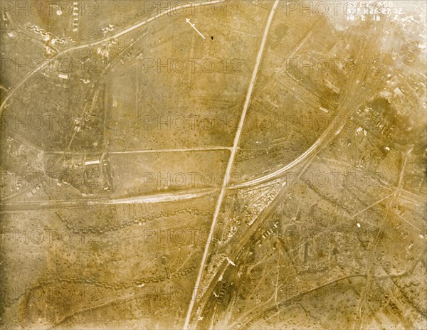 A bomb-damaged landscape on the Western Front. One of a series of British aerial reconnaissance photographs recording the positions of trenches on the Western Front during the First World War. A prominently straight road, possibly one of several Roman roads in the region, and what appears to be a railway track, intersect fields riddled with trenches and bomb craters. Nord-Pas de Calais or Picardie, France, 26 February 1918., Nord-Pas de Calais, France, Western Europe, Europe .