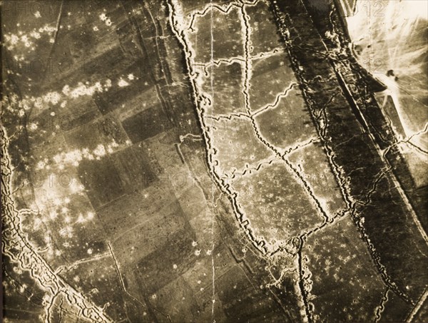 Trenches and bomb damage on the Western Front. One of a series of British aerial reconnaissance photographs recording the positions of trenches on the Western Front during the First World War. A complex trench system is surrounded by fields riddled with bomb craters. This appears to be a stretch of no man's land with two front line trenches facing each other, protected by dark lines of barbed wire. Nord-Pas de Calais or Picardie, France, circa 1918., Nord-Pas de Calais, France, Western Europe, Europe .