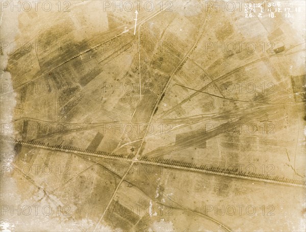 Fields on the Western Front. One of a series of British aerial reconnaissance photographs recording the positions of trenches on the Western Front during the First World War. A line of poplar trees flank a prominently straight road, possibly one of several Roman roads in the region, casting long shadows across the surrounding fields. Nord-Pas de Calais or Picardie, France, 26 February 1918., Nord-Pas de Calais, France, Western Europe, Europe .