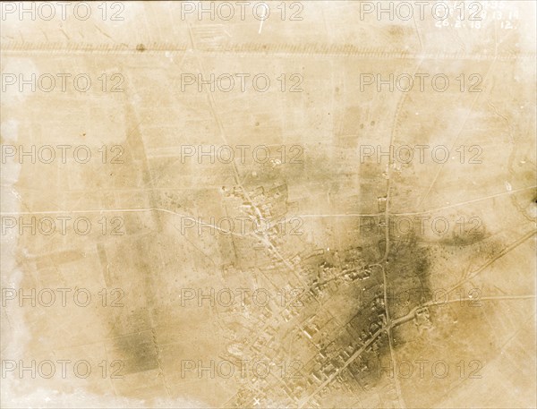 Aerial view of a bomb-damaged landscape. One of a series of British aerial reconnaissance photographs recording the positions of trenches on the Western Front during the First World War. A line of poplar trees flank a prominently straight road, possibly one of several Roman roads in the region, casting long shadows across the surrounding fields. A nearby village lies in ruins after suffering a continuous barrage of artillery fire. Nord-Pas de Calais or Picardie, France, 26 February 1918., Nord-Pas de Calais, France, Western Europe, Europe .