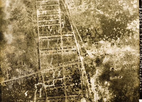 Aerial view of a bomb-damaged town. One of a series of British aerial reconnaissance photographs recording the positions of trenches on the Western Front during the First World War. A French town lies in ruins, riddled with bomb craters after suffering a continuous barrage of artillery fire. A grid-like street system, surrounded by flattened buildings is all that remains. Probably Nord-Pas de Calais or Picardie, France, 31 May 1917., Nord-Pas de Calais, France, Western Europe, Europe .
