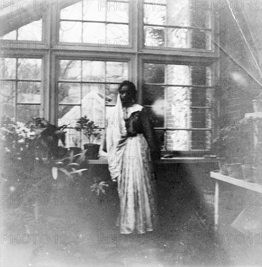 An Indian ayah in England. Portrait of a young Indian ayah (nursemaid) called Nannie, taken in the glass conservatory of a house in Somerset. Nannie worked for a British family (the Lawrences) in India, later moving with them to England where she lived for the rest of her life. Somerset, England, circa 1912., Somerset, England (United Kingdom), Western Europe, Europe .