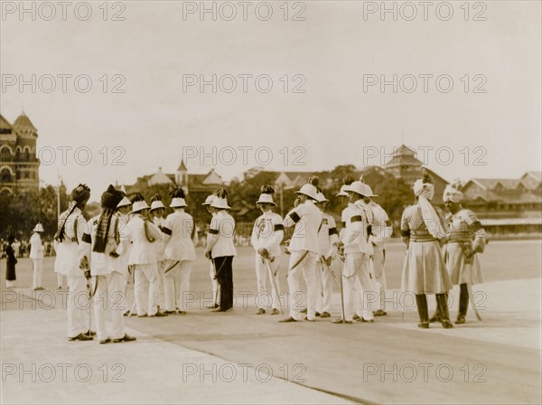 Awaiting the Earl of Reading's arrival. A number of uniformed aides-de-camp chat informally as they await the arrival of the Earl of Reading, a former Viceroy of India, at the Gateway of India. Bombay (Mumbai), India, 1926. Mumbai, Maharashtra, India, Southern Asia, Asia.