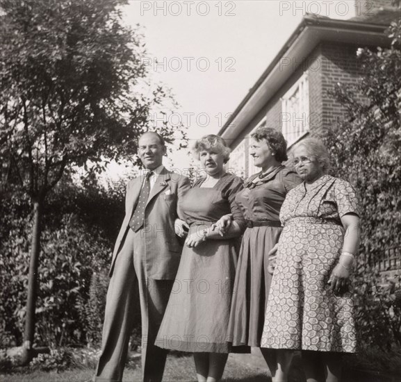 A retired Indian ayah living in England. A retired Indian ayah (nursemaid) called Nannie (far right) poses for a group portrait with members of the Lawrence family for whom she used to work. Nannie was first employed by the family in India, circa 1910, and later moved with them to England where she lived for the rest of her life. England, circa 1955. England (United Kingdom), Western Europe, Europe .