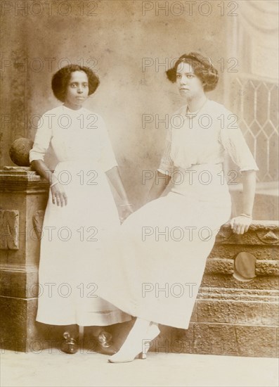 An Indian ayah poses with a European woman. Nannie, an Indian ayah (nursemaid), poses for a studio portrait with a European woman, probably one of her employers. Nannie worked for a British family (the Lawrences) in India, later moving with them to England where she lived for the rest of her life. Location unknown, circa 1914.