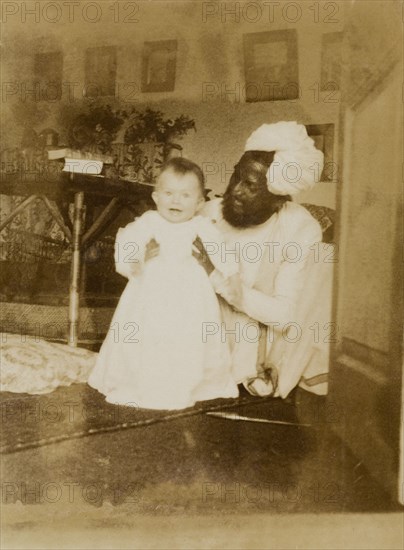 Indian house servant with baby Margaret. An Indian house servant, Hyder Khan, poses playfully with baby Margaret Lawrence (b.1904), the daughter of Sir Henry Staveley Lawrence (a British civil servant) in the Lawrence family's home. India, circa 1905. India, Southern Asia, Asia.