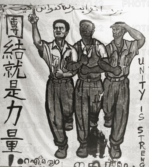 Unity is Strength'. A hand-painted banner campaigns for unity during the Singaporean Merdeka (independence) movement of the 1950s. The text reads 'Unity in Strength' and is written in Malay, Chinese, Tamil and English script. Singapore, circa 1956. Singapore, South East Asia, Asia.
