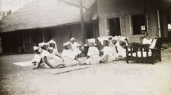 Nigerian schoolgirls attend a tea party. Female students of the Niger Middle School attend a tea party on the lawn of the Senior Education Officer's house. Bida, Nigeria, circa 1950. Bida, Niger, Nigeria, Western Africa, Africa.