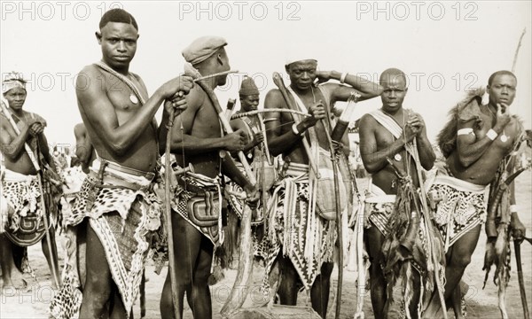 Nigerian hunters with bows and arrows. Portrait of a group of Nigerian hunters with bows and arrows. Naked from the waist up, they wear triangular pieces of cloth and animal skins around their waists. Nigeria, circa 1948. Nigeria, Western Africa, Africa.