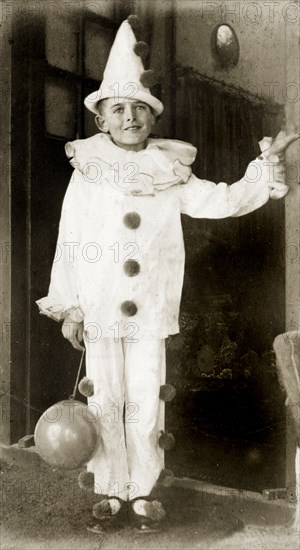 A British boy in fancy dress. Portrait of a British boy wearing a Pierrot clown costume at a fancy dress party. India, circa 1930. India, Southern Asia, Asia.