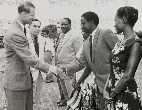 Prince Philip meets officials. Prince Philip, the Duke of Edinburgh, shakes hands with a line of European and African officials. Related images suggest this photograph may have been taken during the Prince's visit to Dar-es-Salaam to mark Tanzania's independence from the United Kingdom. Probably Dar es Salaam, Tanganyika (Tanzania), December 1961. Dar es Salaam, Dar es Salaam, Tanzania, Eastern Africa, Africa.