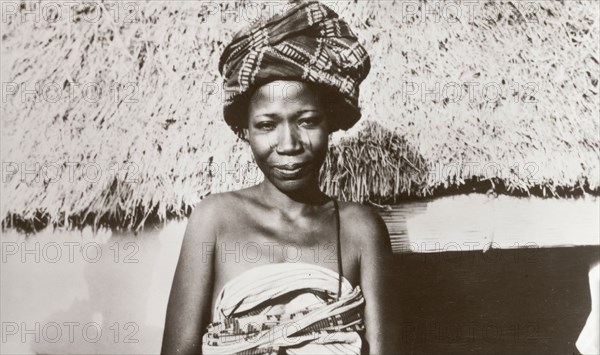 Portrait of a Hausa woman. Head and shoulders portrait of a Hausa woman, dressed in a traditional patterned robes and a head wrap. Nigeria, circa 1940. Nigeria, Western Africa, Africa.