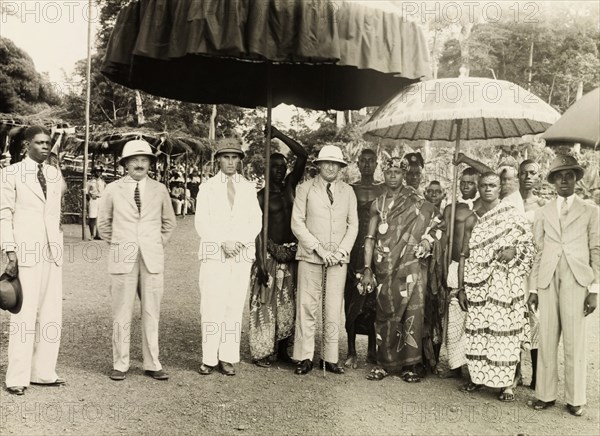 Sir Alan Burns at the Obuasi Durbar . British colonial administrators including Sir Alan Burns (1887-1980), Governor of the Gold Coast, pose for a group portrait with the Adansihene (Chief of Adansi) and his retinue, under ceremonial umbrellas at the Obuasi Durbar. Obuasi, Asante, Gold Coast (Ghana), 1943. Obuasi, Ashanti, Ghana, Western Africa, Africa.