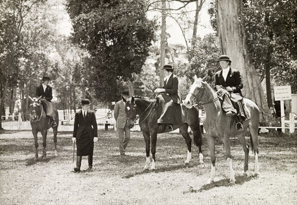 Siddle-saddle' class at Nairobi Show. Three ladies participating in the 'siddle-saddle' class at the Nairobi Show face the scrutiny of judge Dr Mary Harris. Nairobi, Kenya, 1957. Nairobi, Nairobi Area, Kenya, Eastern Africa, Africa.