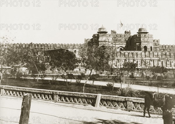 View of Agra Fort. View of Agra Fort, taken from a nearby road bridge. The Delhi Gate projects from the fortified red sandstone walls that surround the complex. Agra, United Provinces (Uttar Pradesh), India, circa 1920. Agra, Uttar Pradesh, India, Southern Asia, Asia.