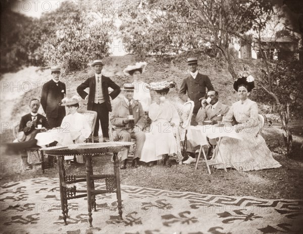 A Victorian picnic. A group of Victorian men and women drink cups of tea whilst picnicking in the gardens of Penshew House. Bangalore, India, circa 1900. Bangalore, Karnataka, India, Southern Asia, Asia.