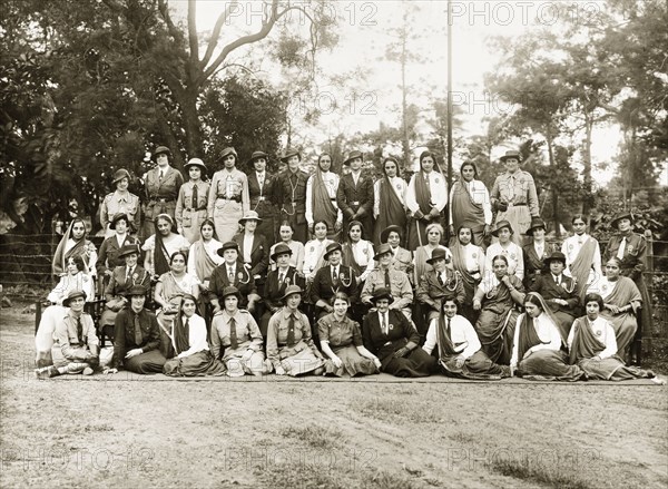 Girl Guides in India. European and Indian Girl Guides and Girl Guide leaders pose for a group portrait outdoors. India, circa 1930. India, Southern Asia, Asia.