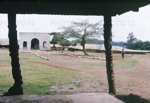 Yoruba chief's palace. View from beneath a porch with carved wooden pillars, looking towards the arched entrance of a Yoruba chief's palace or compound. Oyo, Western Region (Oyo State), Nigeria, October 1963. Oyo, Oyo, Nigeria, Western Africa, Africa.