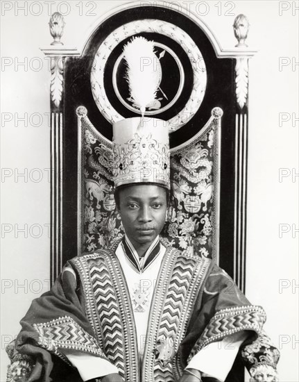 Edward Mutesa II, Kabaka of Buganda. Portrait of Edward Mutesa II, Kabaka (King) of Buganda, seated in an ornately decorated throne. Uganda, circa 1955. Uganda, Eastern Africa, Africa.