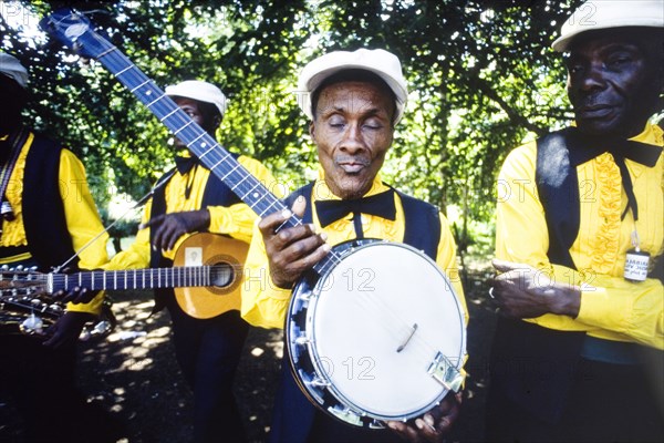 Banjo player at the Caribbean Music Village. A musician holds up his banjo as his band prepare to play at the Caribbean Music Village, a cultural festival held at the Commonwealth Institute. London, England, 7-26 July 1986. London, London, City of, England (United Kingdom), Western Europe, Europe .