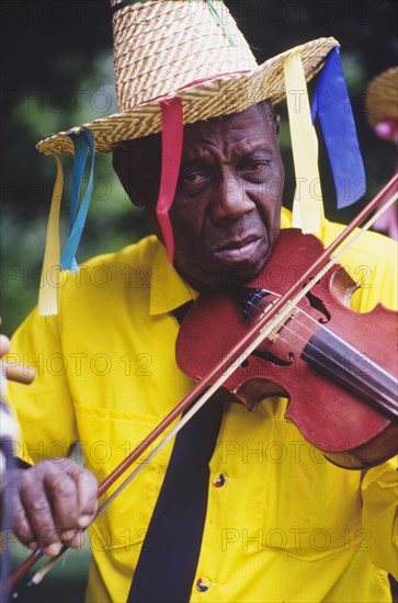 Violinist at the Caribbean Music Village. A musician plays a violin at the Caribbean Music Village, a cultural festival held at the Commonwealth Institute. London, England, 7-26 July 1986. London, London, City of, England (United Kingdom), Western Europe, Europe .