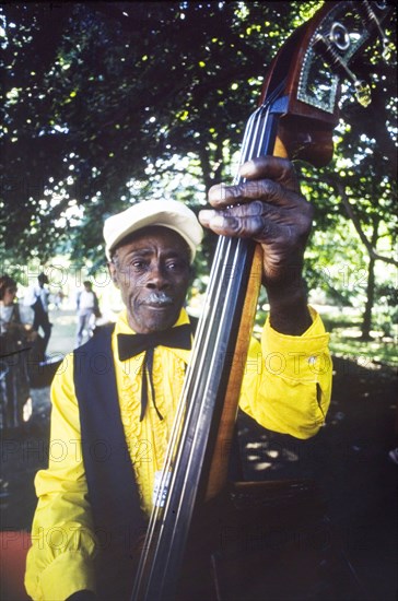 Musician at the Caribbean Music Village. A band musician plays the double bass at the Caribbean Music Village, a cultural festival held at the Commonwealth Institute. London, England, 7-26 July 1986. London, London, City of, England (United Kingdom), Western Europe, Europe .